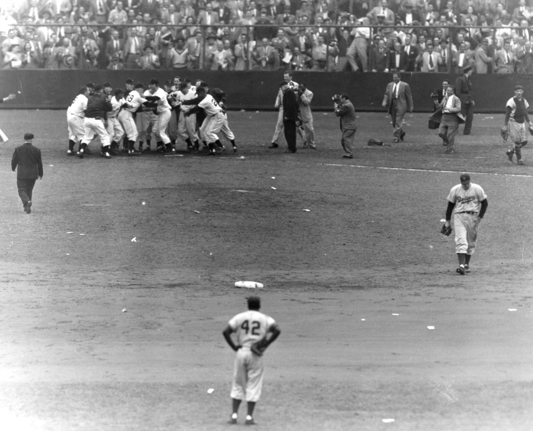Players greet Thomson at home plate after he hits the game winning home run.