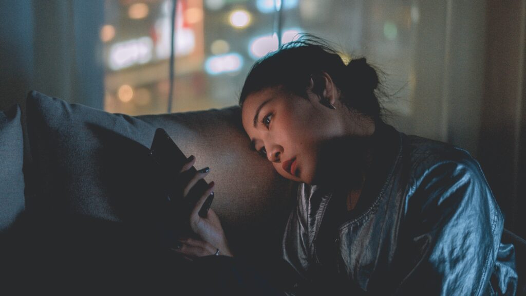 Woman on phone at night in a dark room