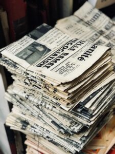 A stack of newspapers sit on a table. Fabien Barrel via Unsplash