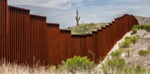 Image of the US border wall in an arid landscape.