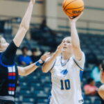 Author making a basket during women's basketball game.