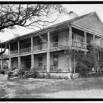Photo of the Seward Plantation House, in Independence Texas. It is a two story structure, rectangular shape with a large two story front porch running the length of the home